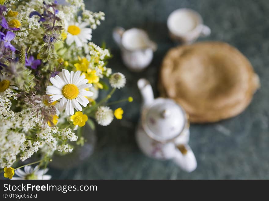 Teapot, flowers, milk,kefir and plate of pancakes. Teapot, flowers, milk,kefir and plate of pancakes