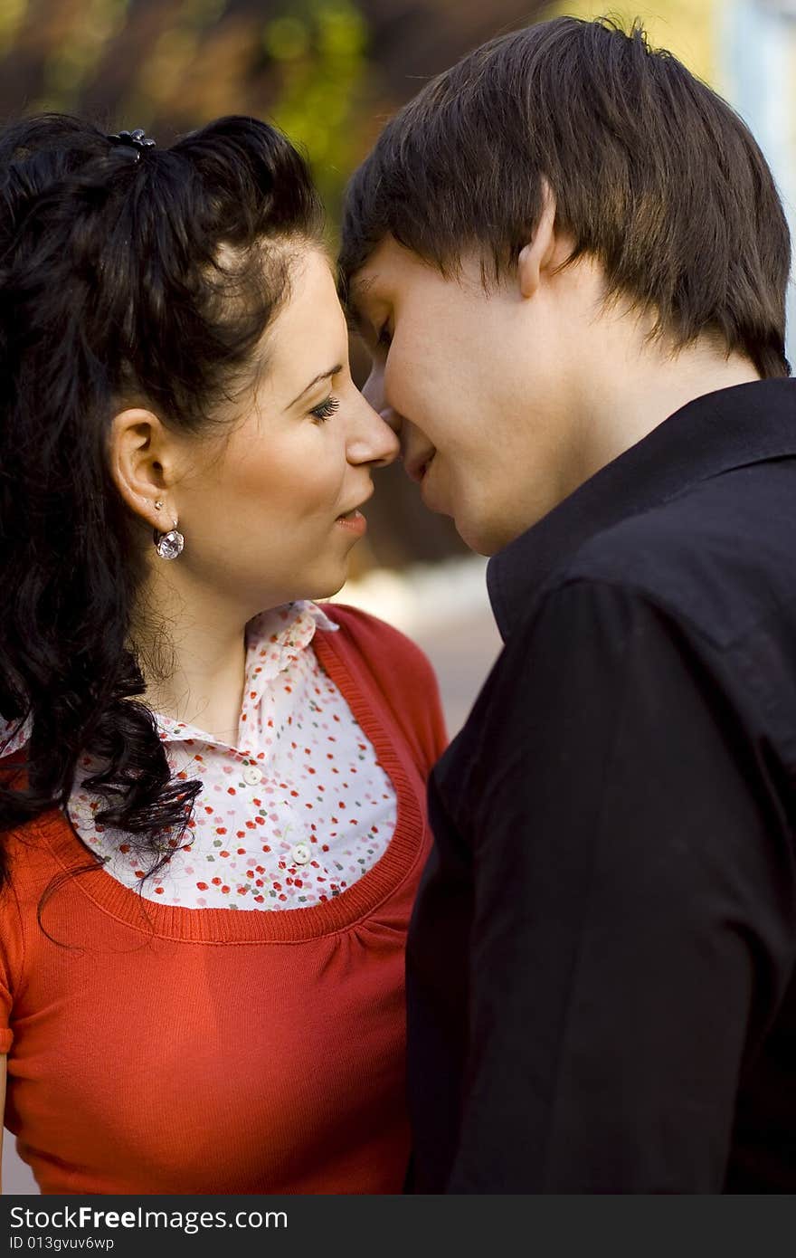 Outdoor portrait of young loving couple kissing and hugging each other