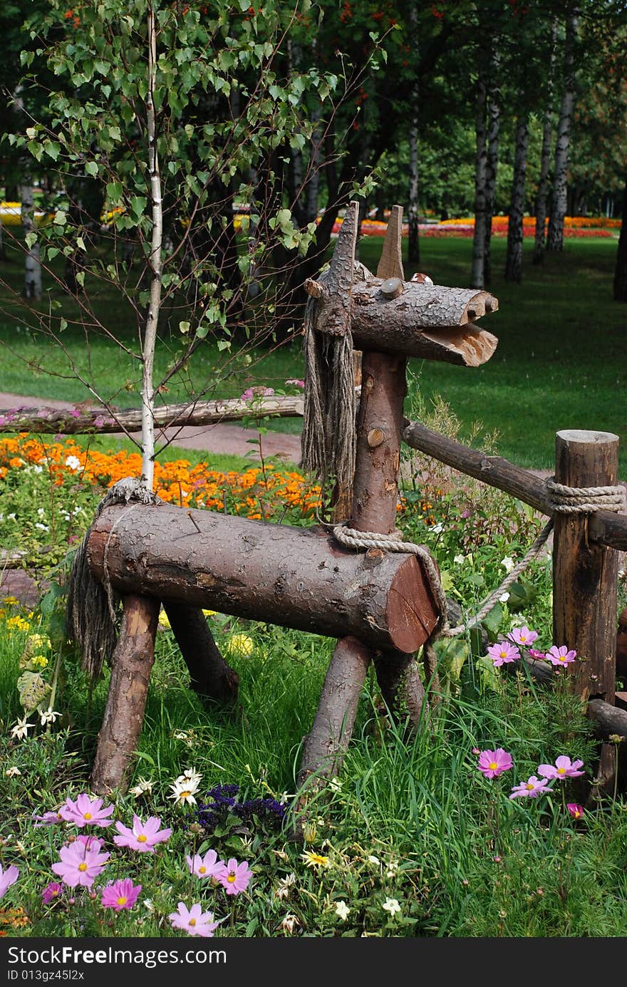 Wooden horsy in a park flower bed