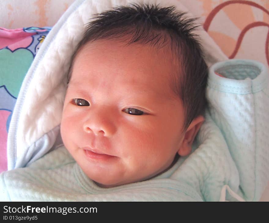 A Chinese baby on a bed. A Chinese baby on a bed