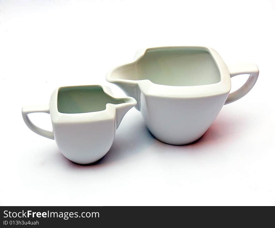 Two white ceramic milk pots isolated on white background.