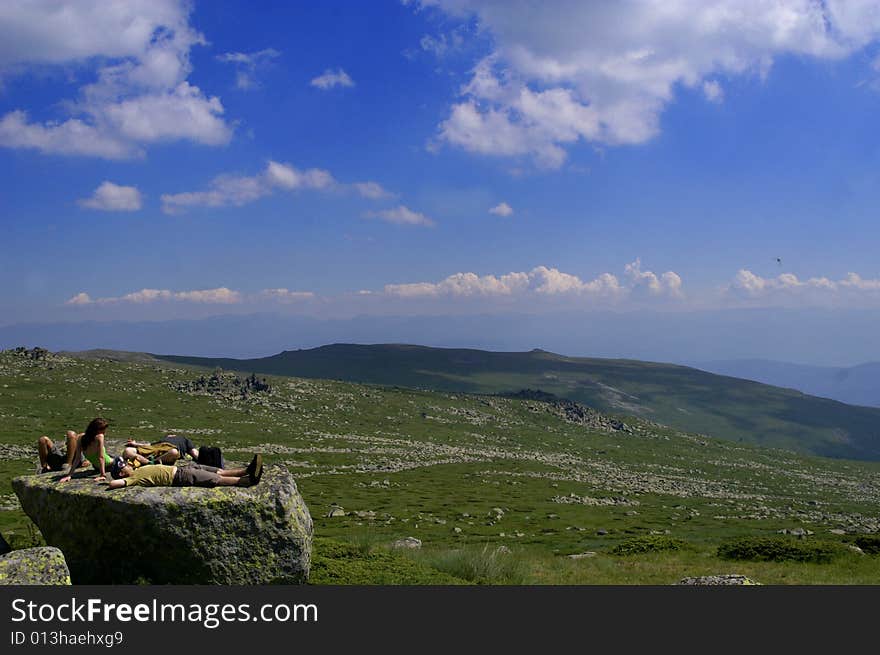 Young people relax on the moutain rock