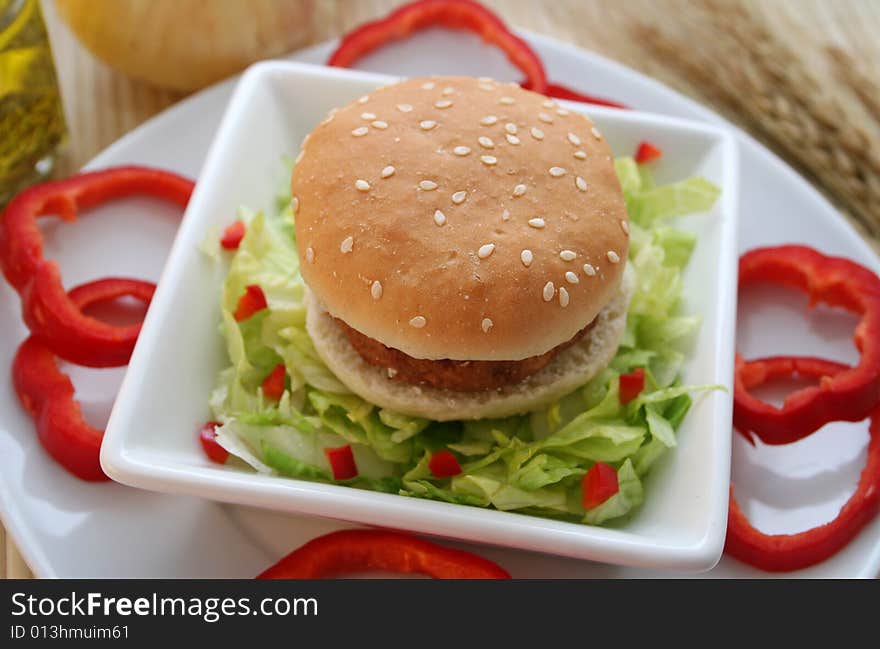 A meal of a little Burger with some salad. A meal of a little Burger with some salad