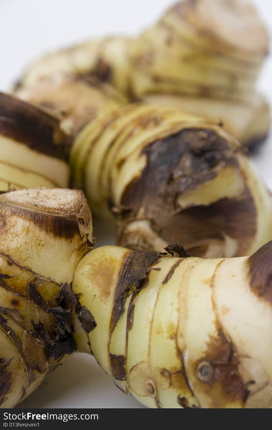 A stack of galangal root isolated against a white background