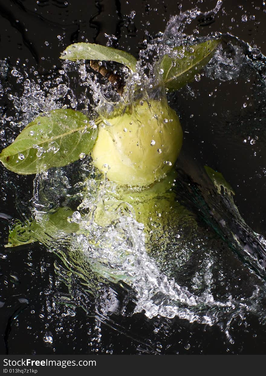 Fresh apple with water splashes on a mirror surface. Fresh apple with water splashes on a mirror surface