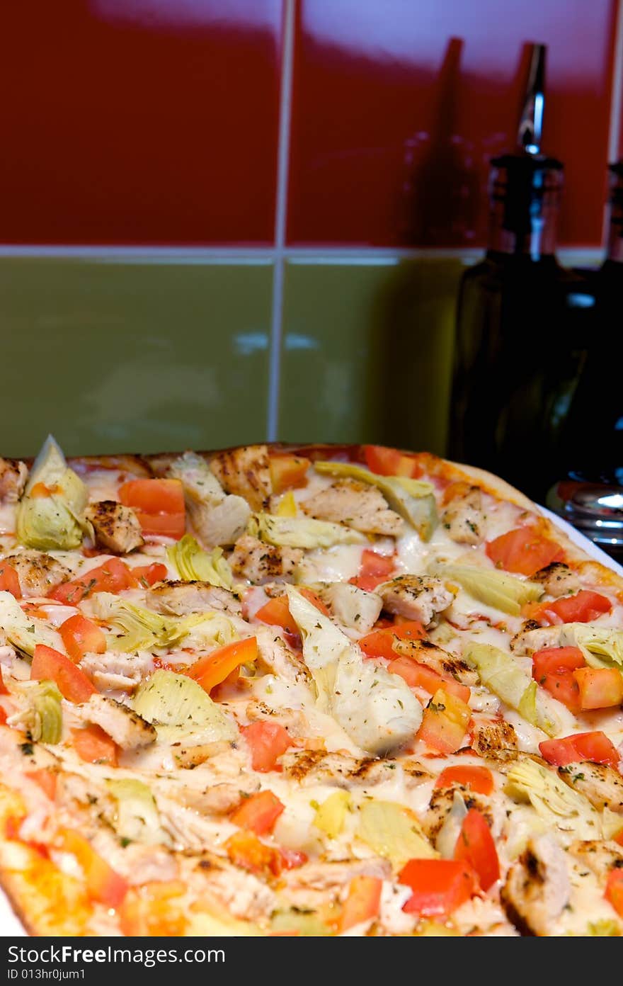 An image of Greek style pizza with artichokes and chicken