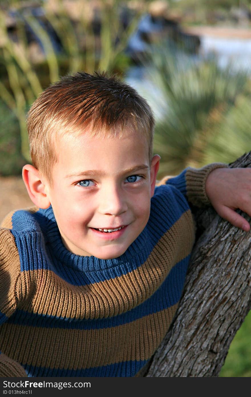 Boy Smiling Leaning on Tree. Boy Smiling Leaning on Tree