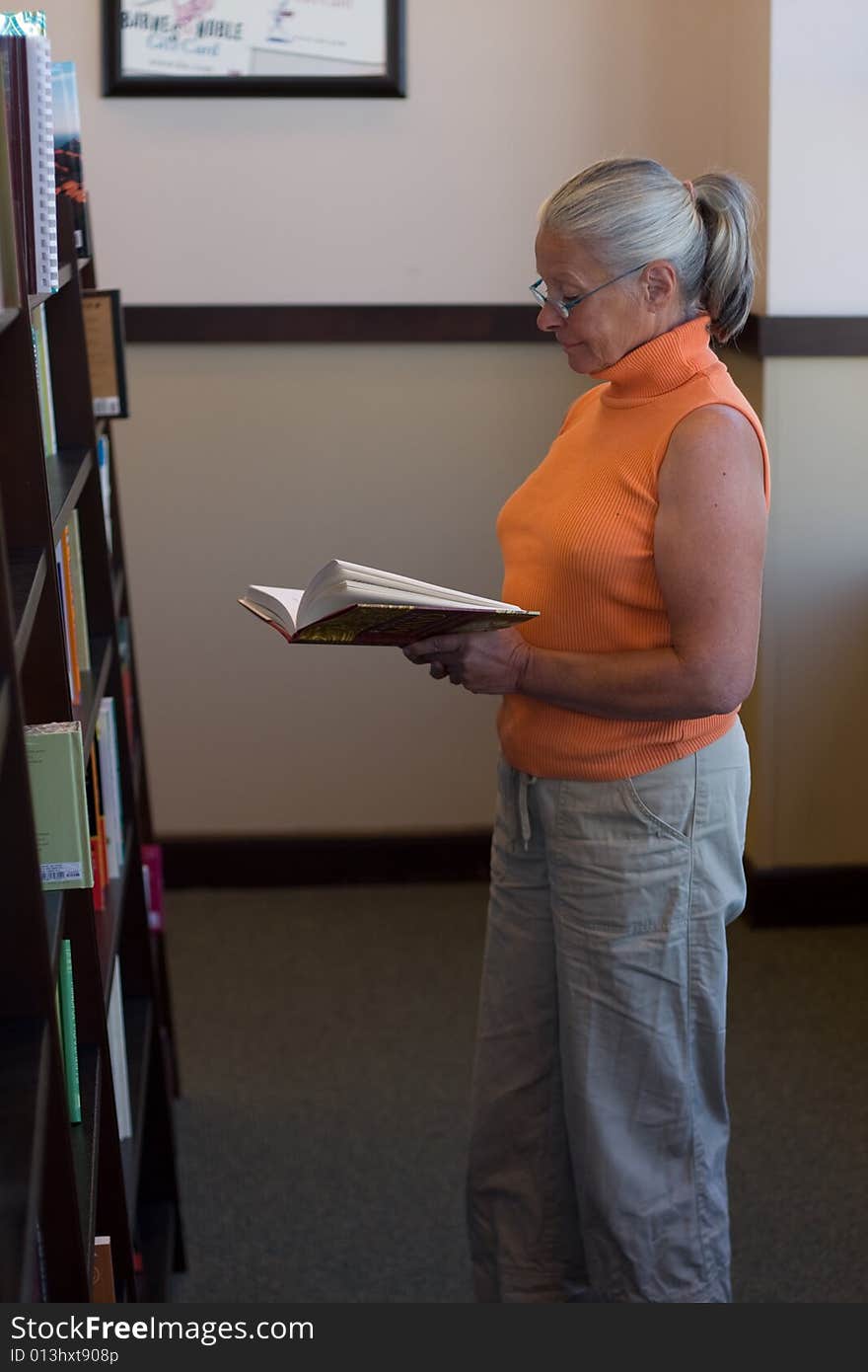 Senior woman reading in bookstore