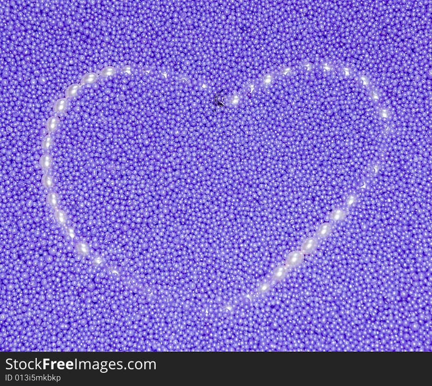 Heart from pearls beads on a lilac background