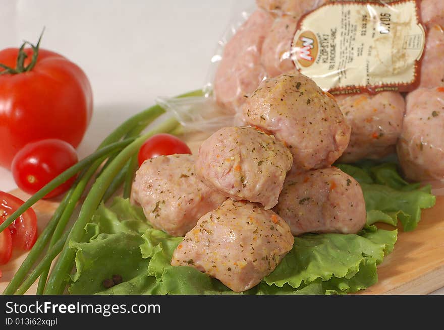 Meatball on the lettuce with tomatoes and green onion