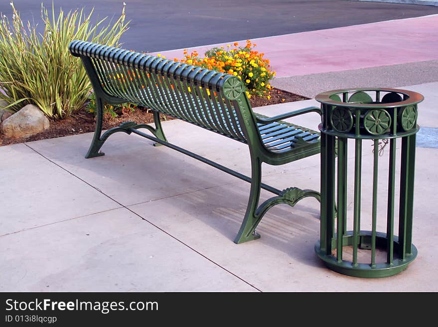 Back of a park bench and trash can