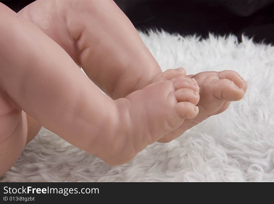 Plastic baby feet on a soft blanket