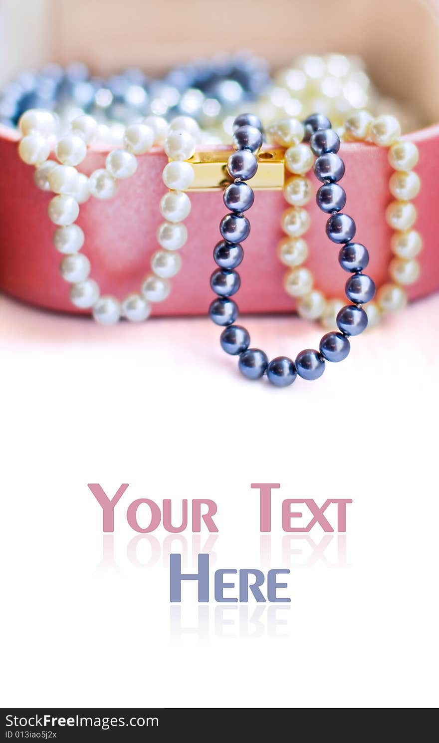 Colorful artificial pearl beads in a chest for jewels with copyspace for your text