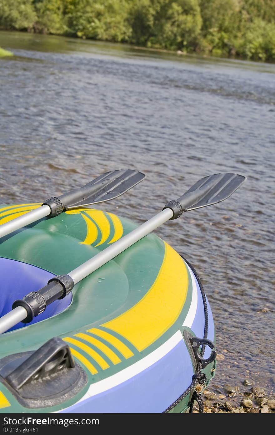 Tourist boat  with two oars on a bank of river