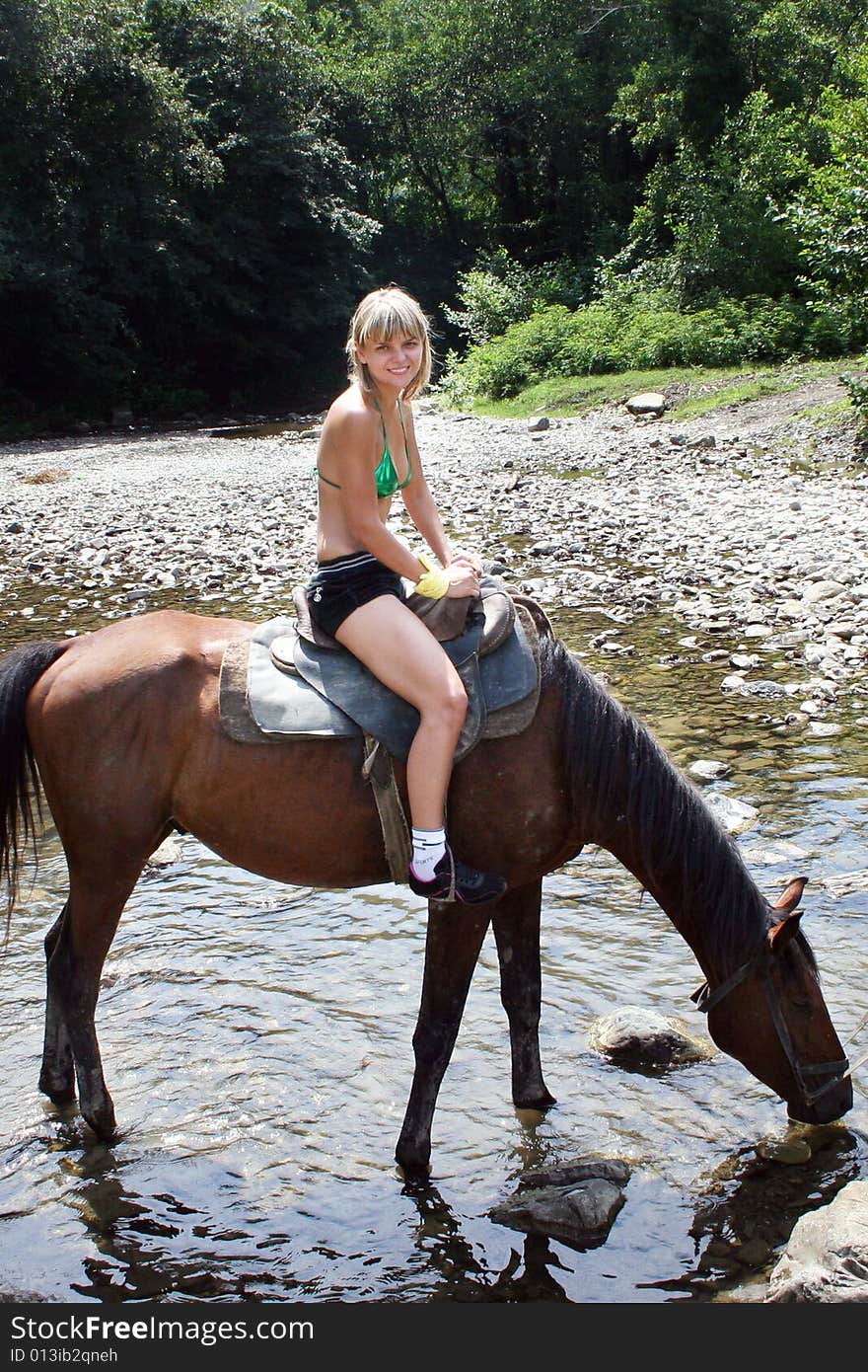 Beautiful making look younger girl sits in saddle on on walk in mountain. Beautiful making look younger girl sits in saddle on on walk in mountain