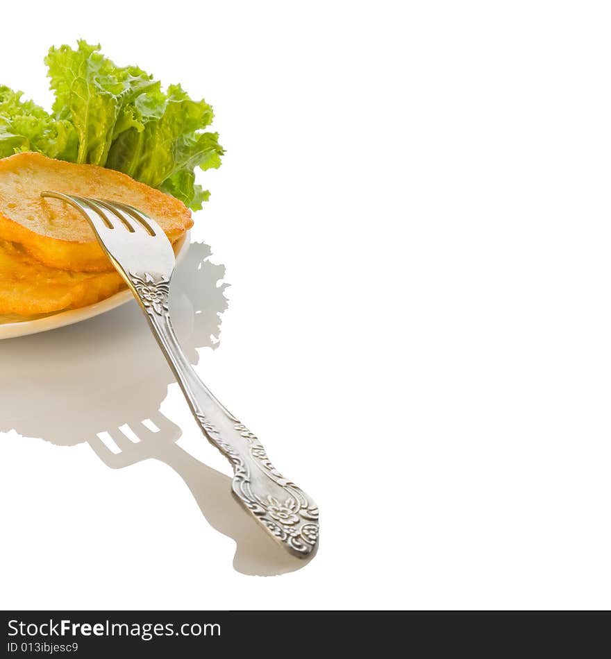 Fragment roasted potato pancakes with green salad on the plate, metal fork, copy space for the text