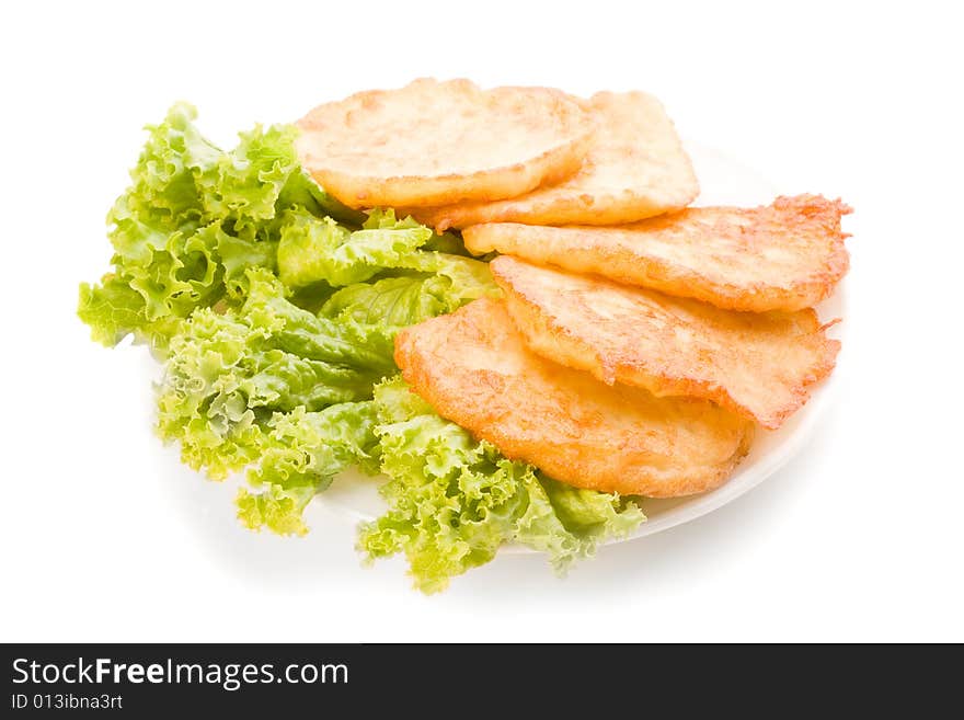 Isolated potato pancakes on the plate with green salad, food photo