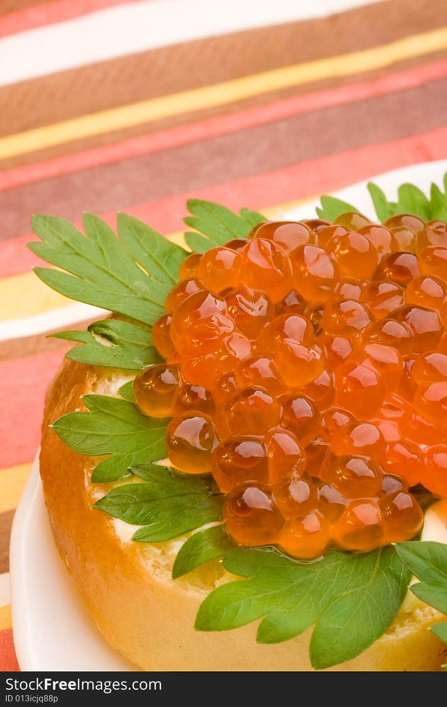 Macro closeup sandwich with red caviar and green parsley