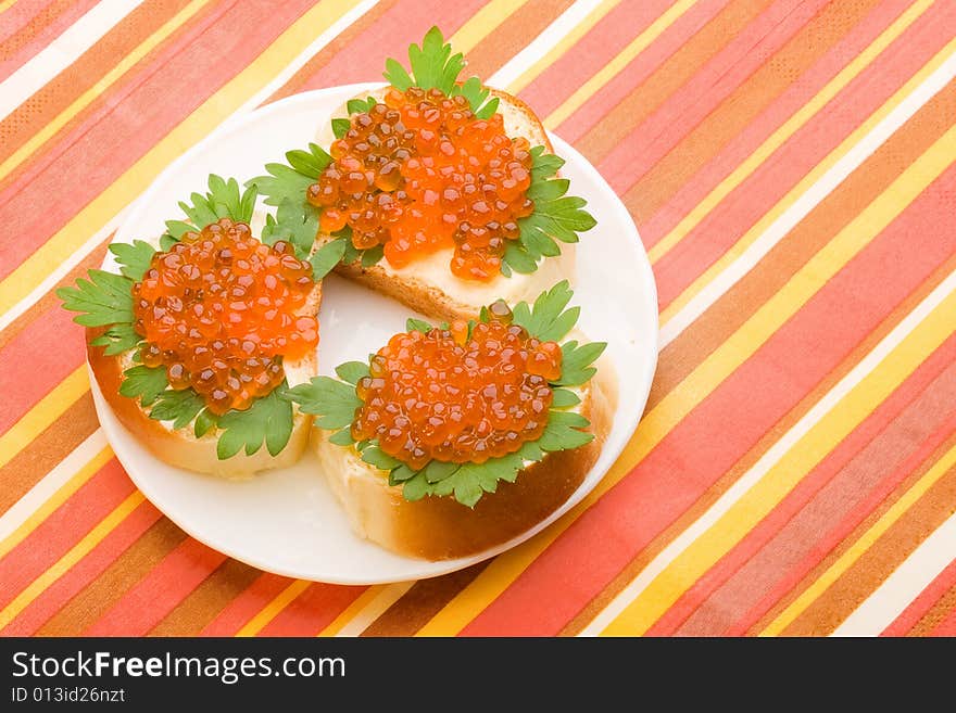 Sandwiches with butter green parsley and red salmon caviar on the plate. Sandwiches with butter green parsley and red salmon caviar on the plate