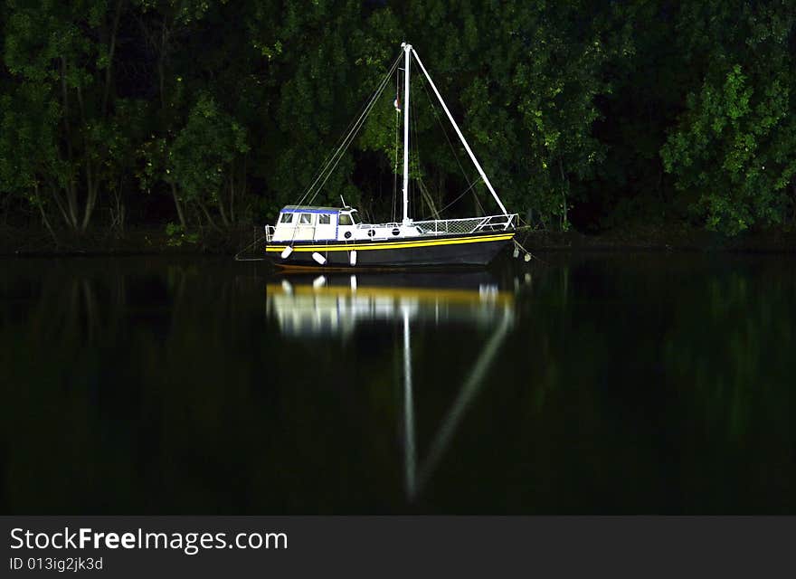 Small boat docked on river by night. Small boat docked on river by night.