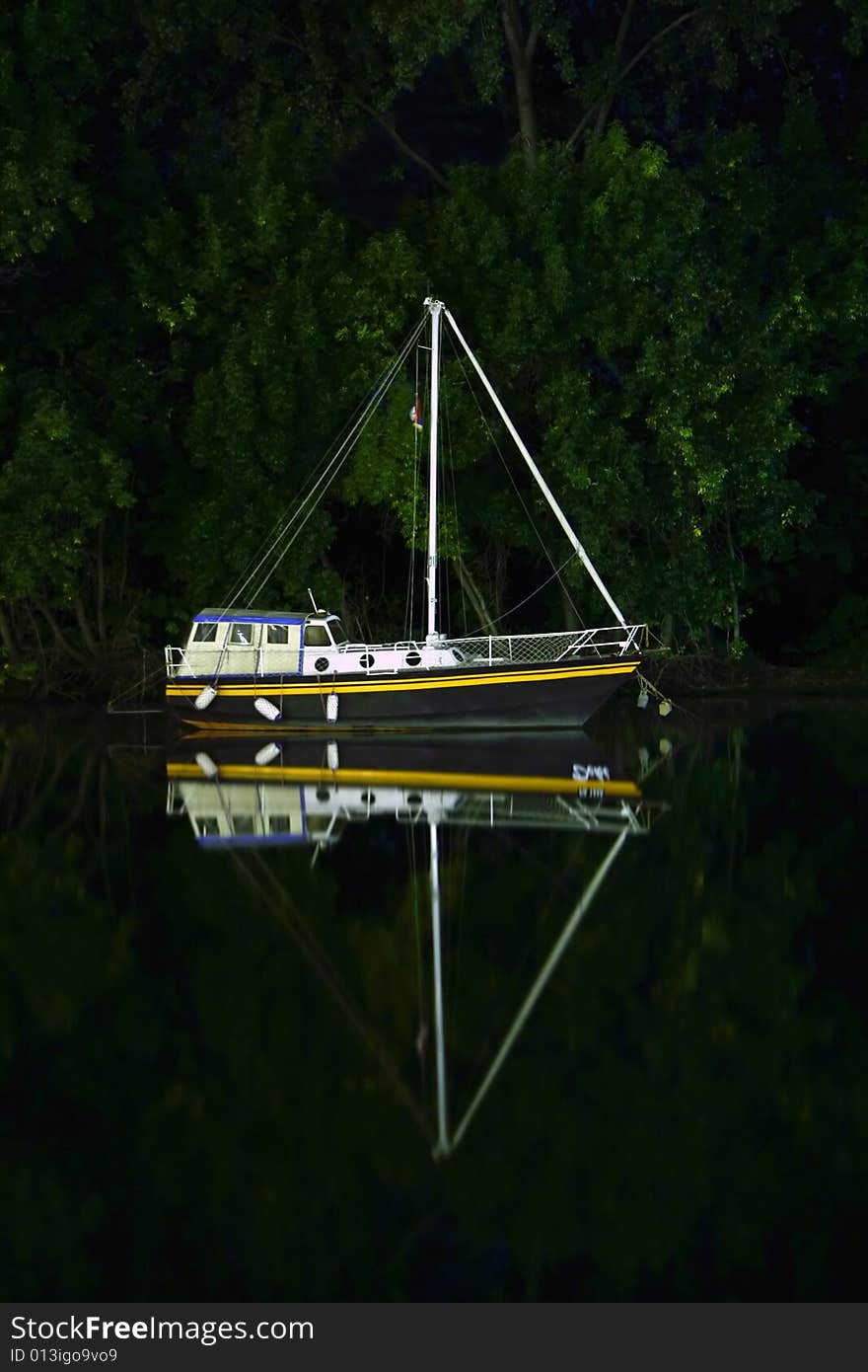 Small boat docked on river by night. Small boat docked on river by night.