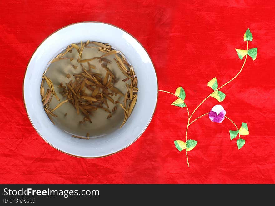 A cup of tea on a Chinese style table cloth. A cup of tea on a Chinese style table cloth