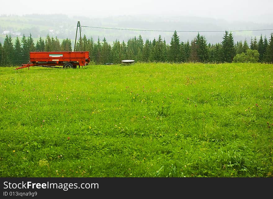 Red trailer on the foggy green hill. Red trailer on the foggy green hill