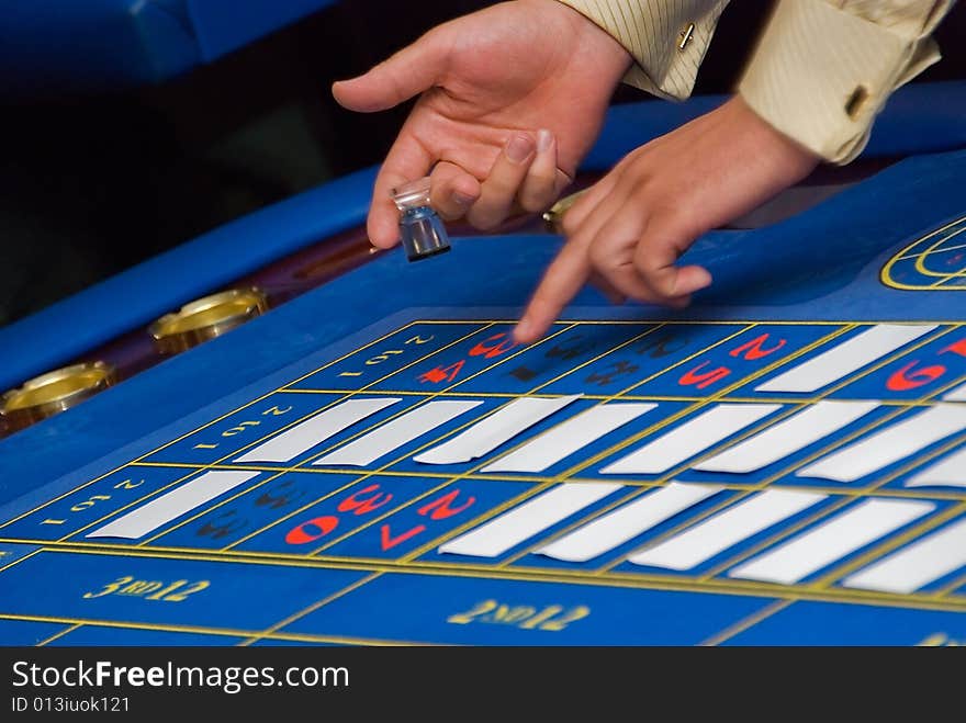 Croupiers hands under the blue roulette table. Croupiers hands under the blue roulette table