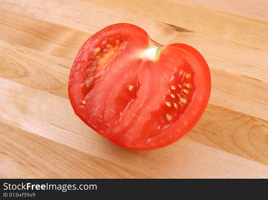 Tomato on wooden kitchen board