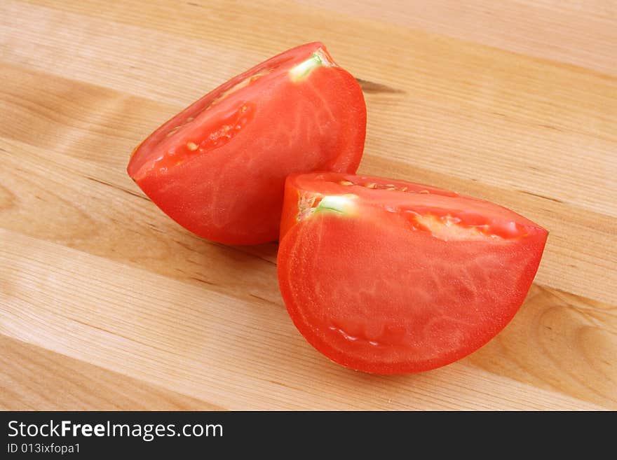 Tomato on wooden kitchen board