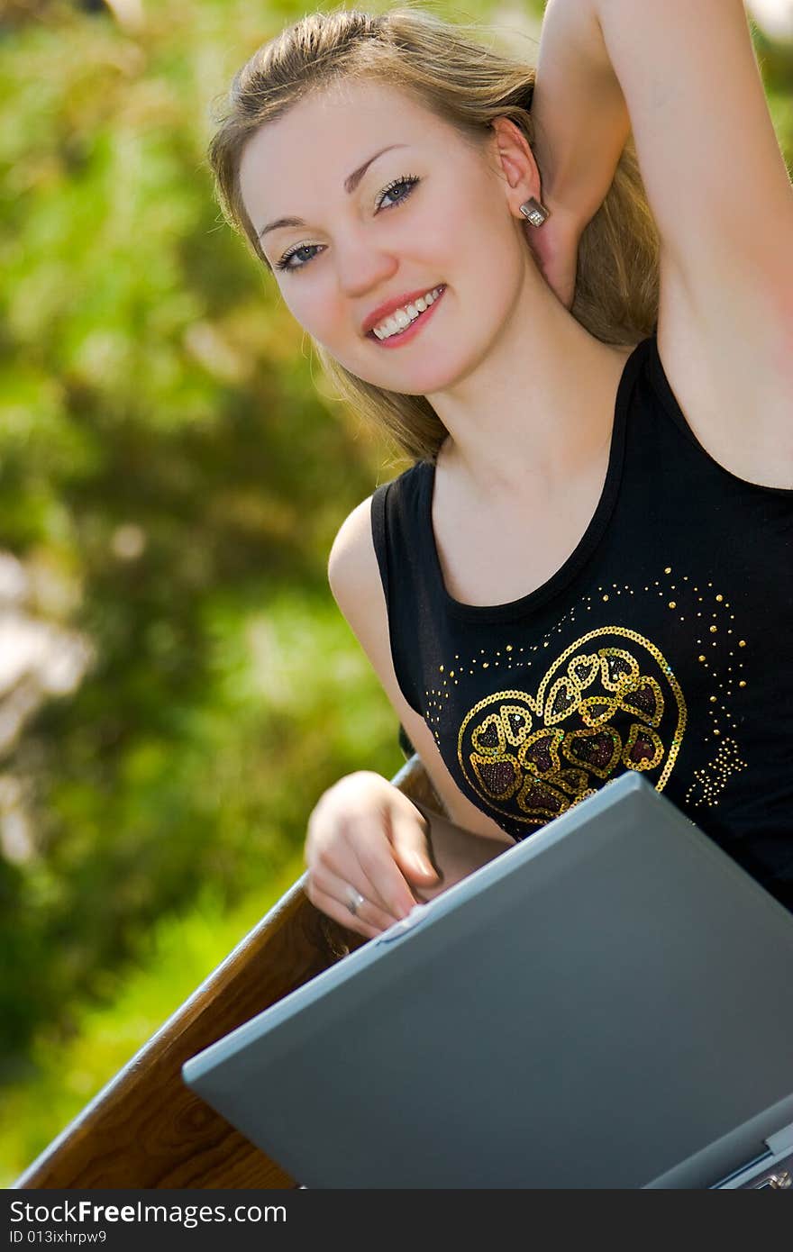 Happy young woman with laptop outdoors shot