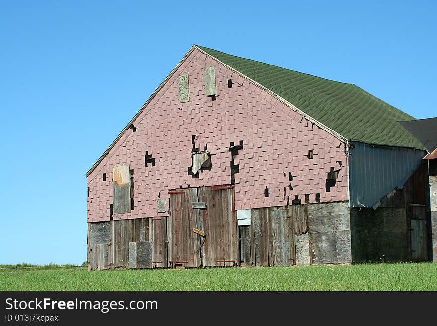 Old barn with grass and blue sky