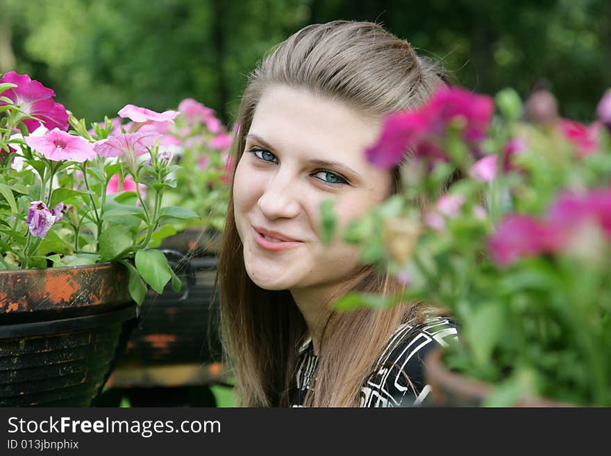 Portrait of the beautiful girl among blossoming plants