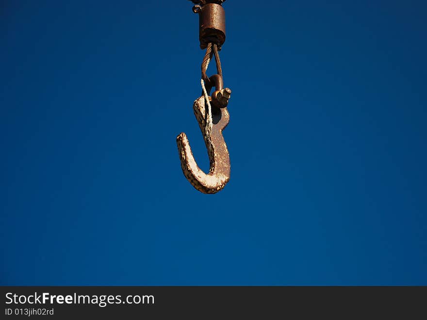 Rusty hook on a blue sky background. Rusty hook on a blue sky background