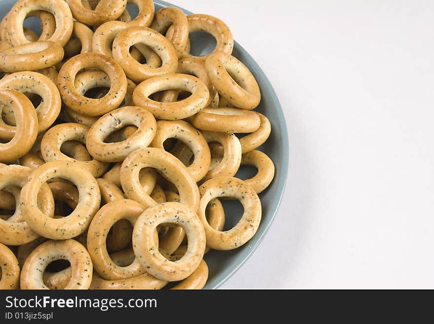 Heap of bread ring in a blue plate on a white background.