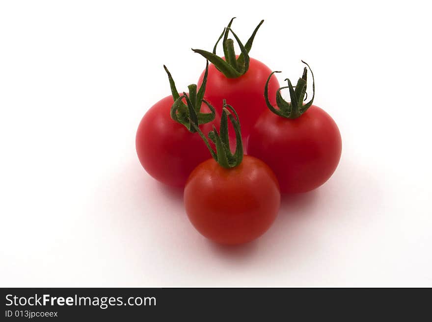 Four cherry tomatoes set against a white backdrop. Four cherry tomatoes set against a white backdrop