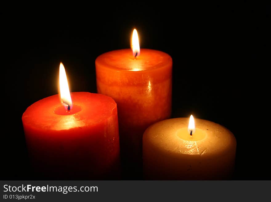 Three candles burning with a black back ground. Three candles burning with a black back ground.