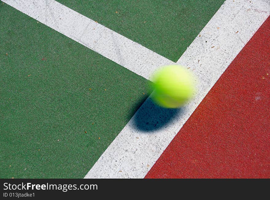A tennis ball bouncing on the line of a court