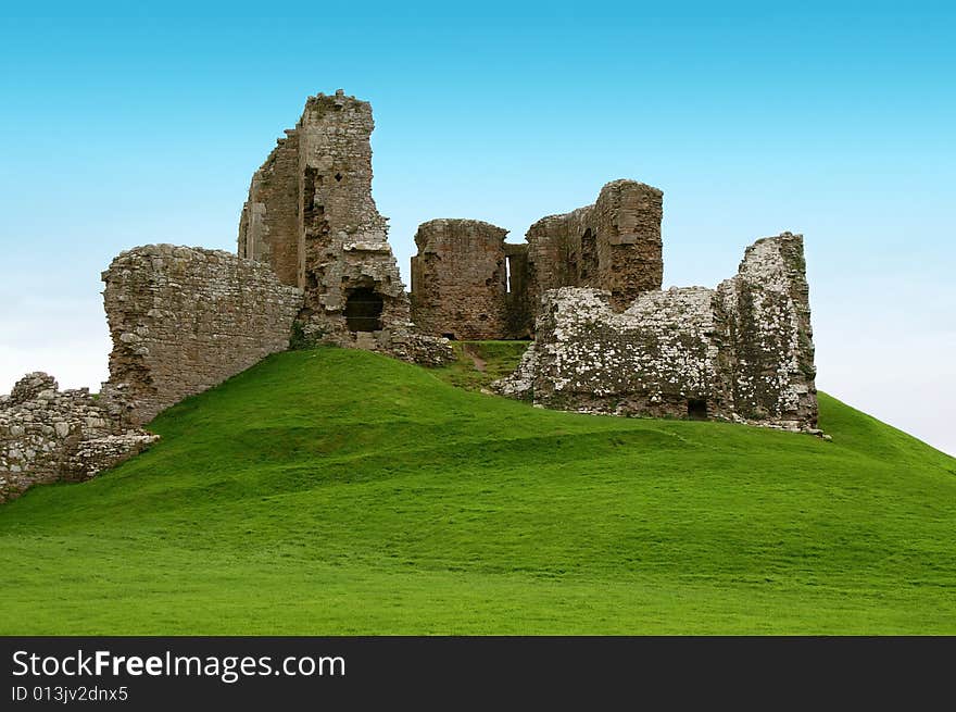 Ancient ruins on a green hill covered with grass