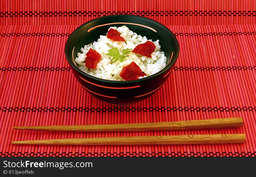 Chinese food in a black plate and sticks