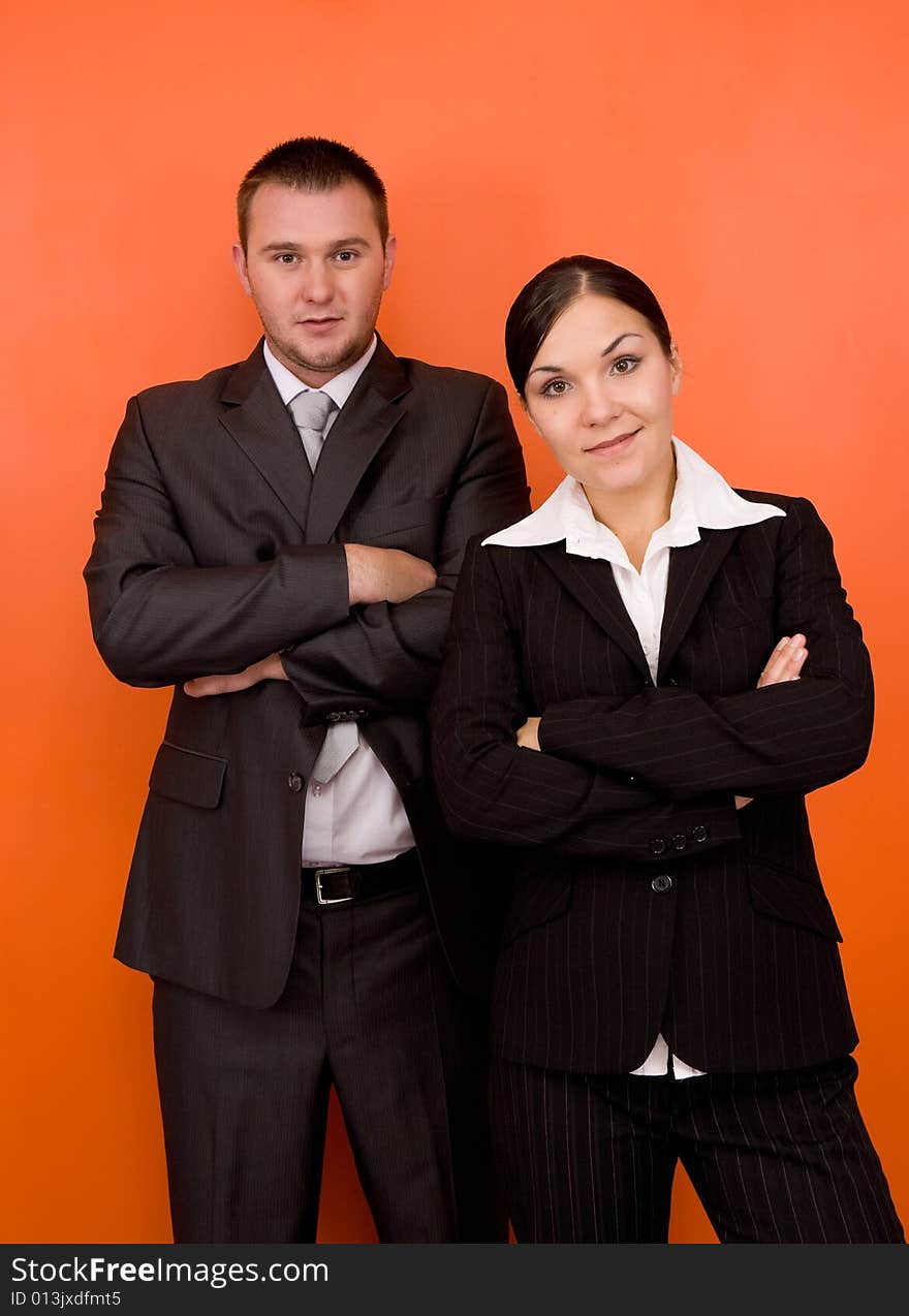 Businesswoman and businessman in team standing on orange background. Businesswoman and businessman in team standing on orange background