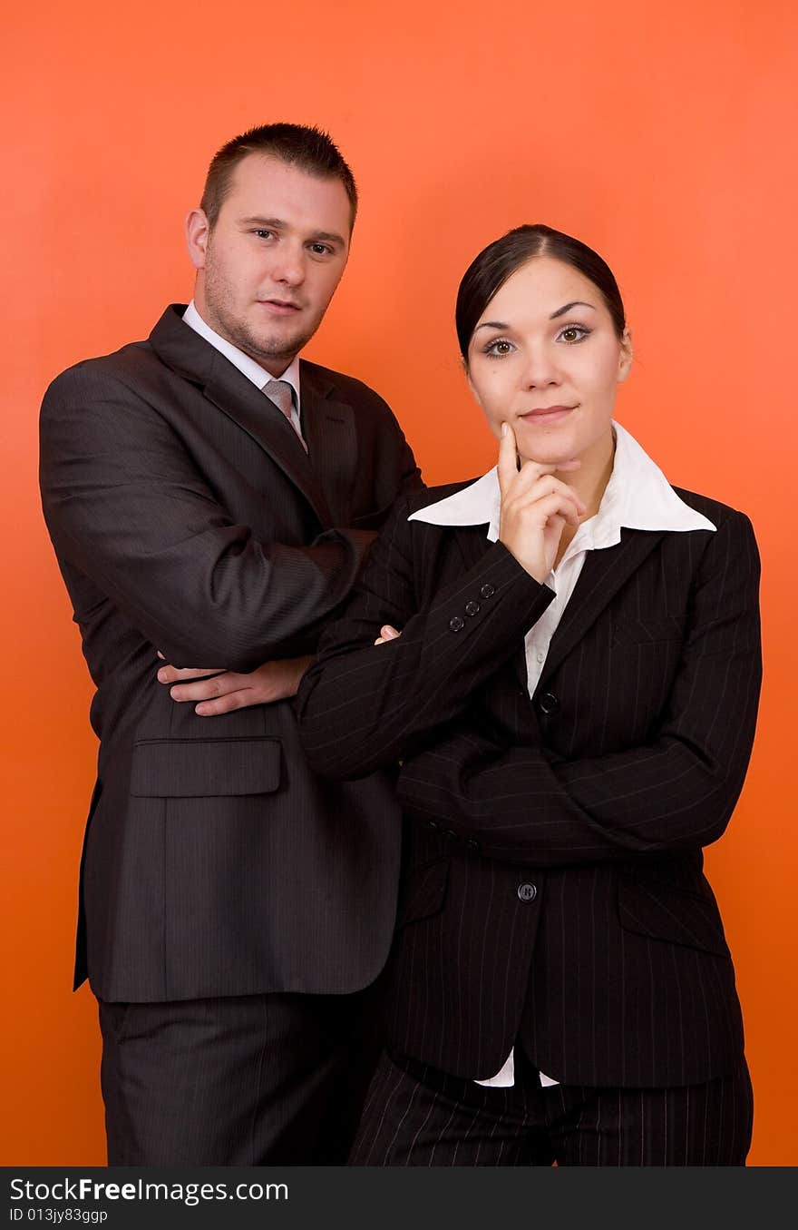 Businesswoman and businessman in team standing on orange background. Businesswoman and businessman in team standing on orange background