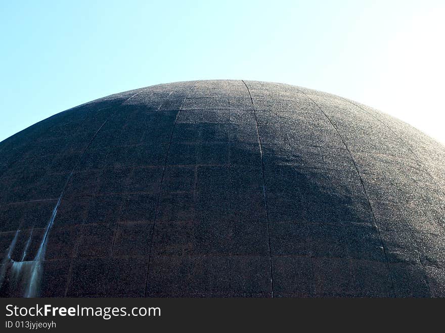 Large cement dome half in sunshine against a pale sky