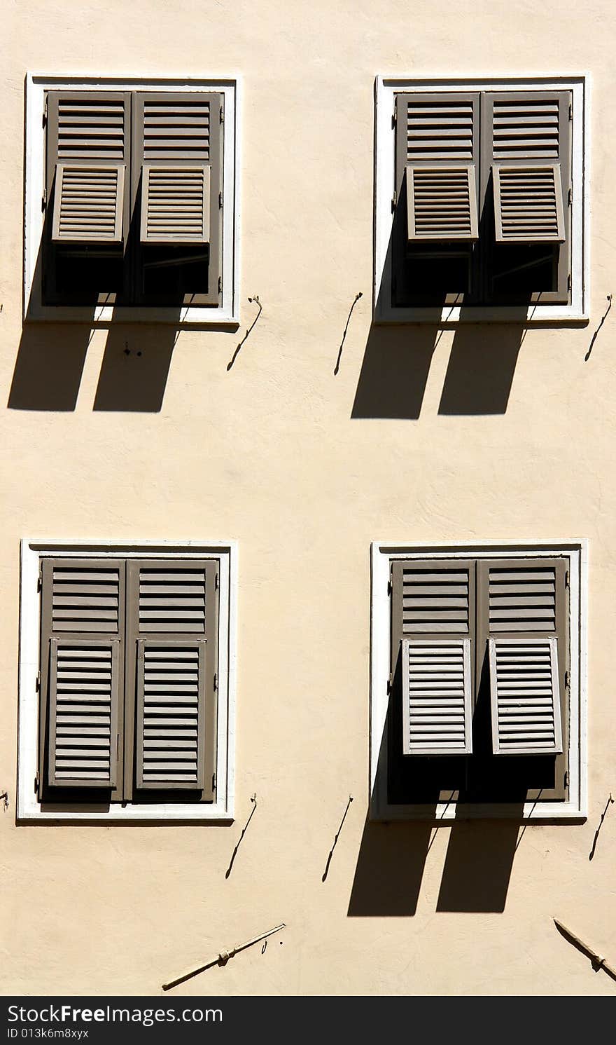 Four windows and shades on an old house