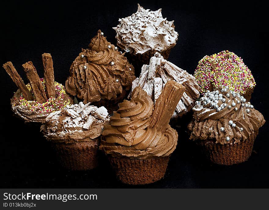 Cup cakes/Muffins suitable for a birthday card or celebration card.chocolate fondant icing and silver balls, icing sugar, flakes and sprinkles. Cup cakes/Muffins suitable for a birthday card or celebration card.chocolate fondant icing and silver balls, icing sugar, flakes and sprinkles