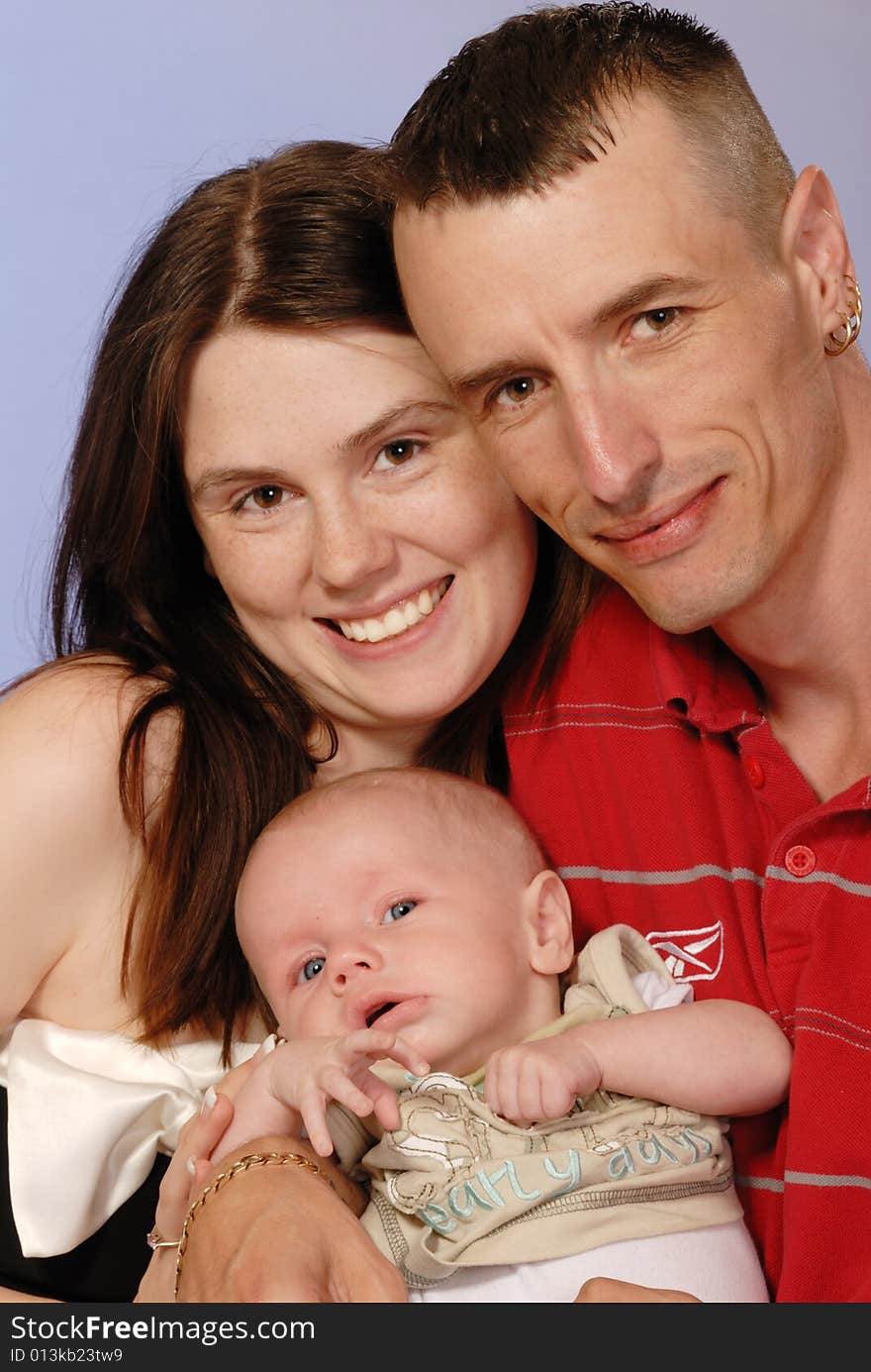 Mother, father and young baby boy posing for camera. Mother, father and young baby boy posing for camera