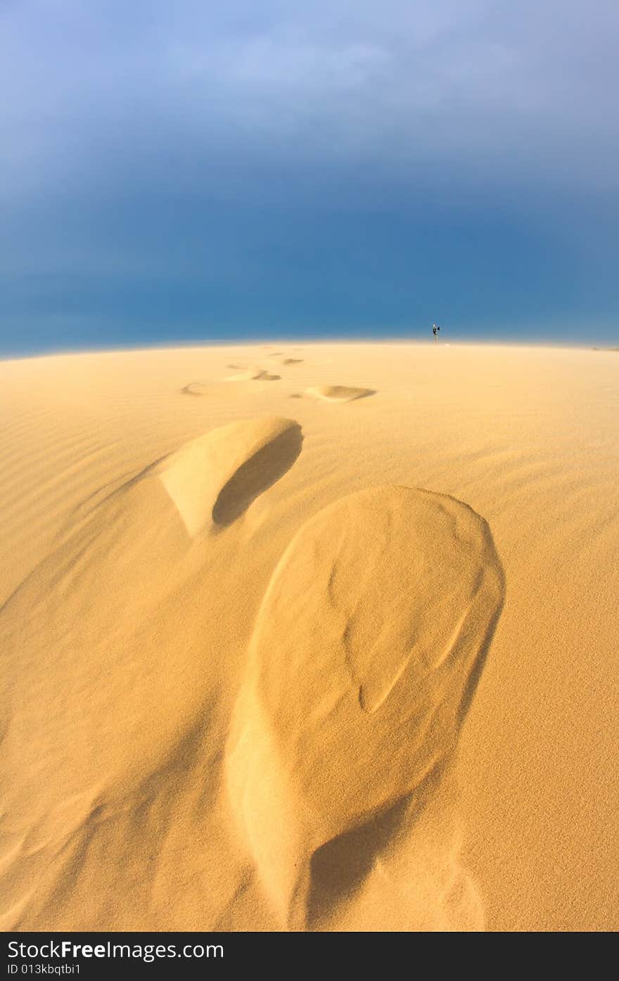 Windswept sand dunes on a blue sky