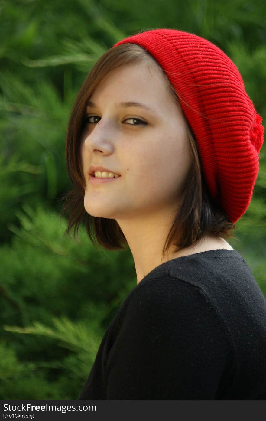 A portrait of a young girl with red cap.