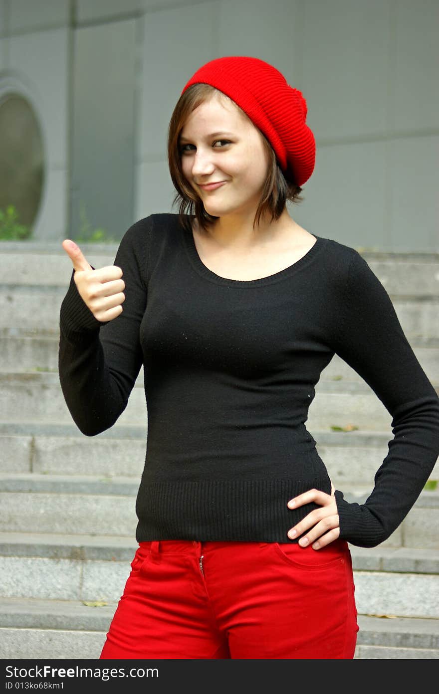 Girls With Red Cap Stretches Thumb In The Air