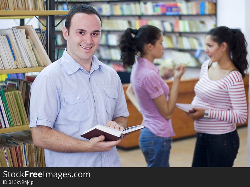 Three happy students in library. Three happy students in library